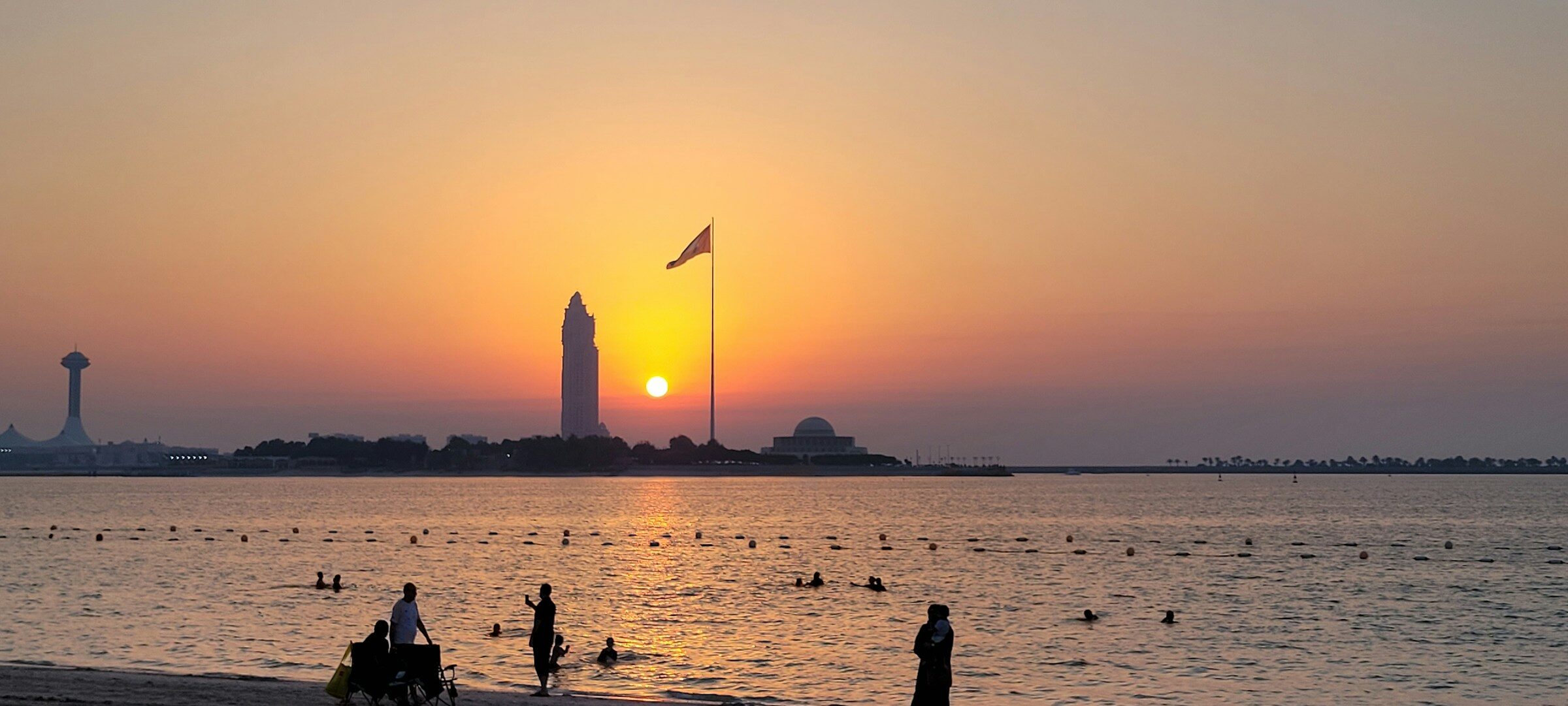 The sun setting over the water at the Corniche beach
