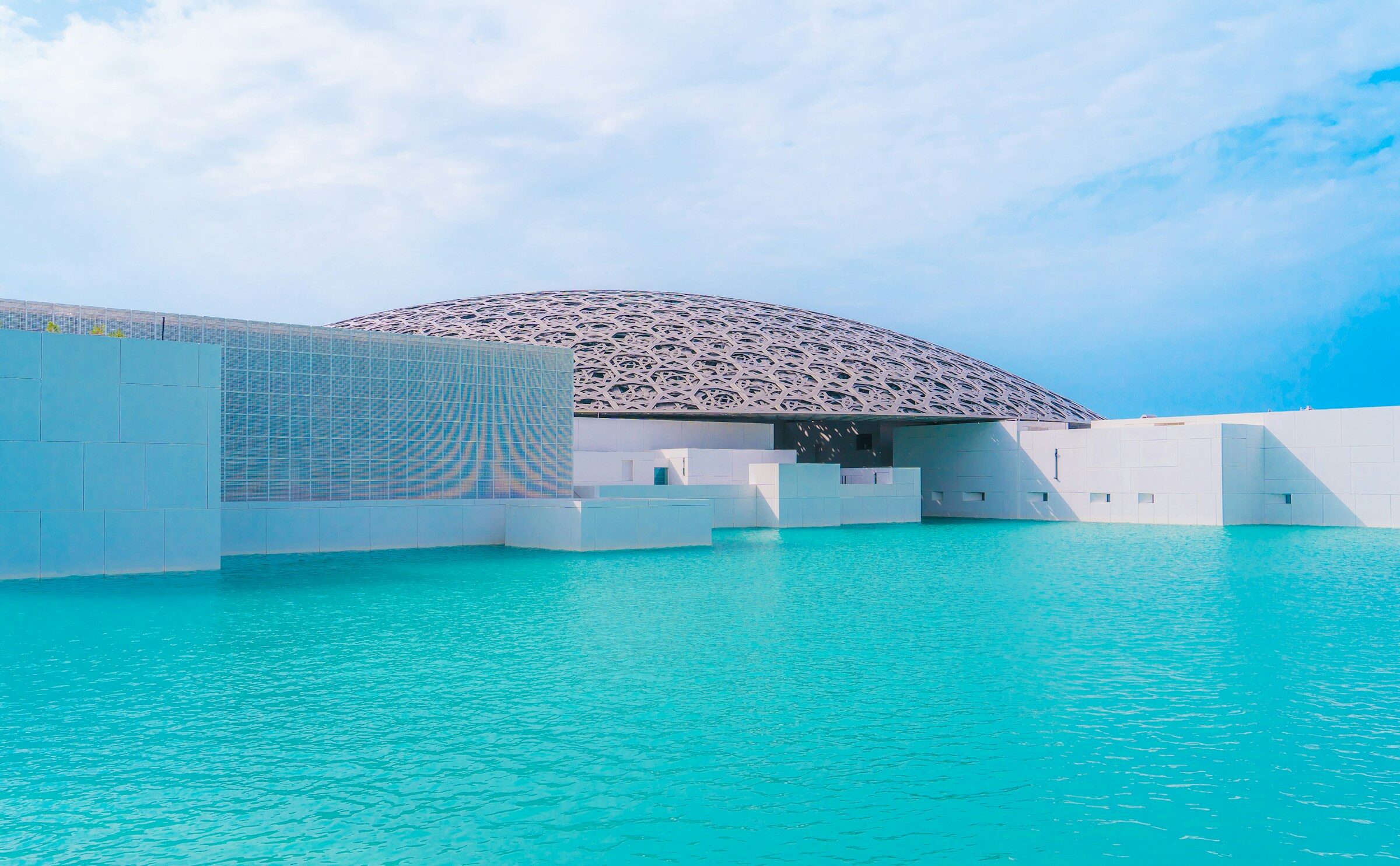 The domed Louvre Abu Dhabi next to the sea
