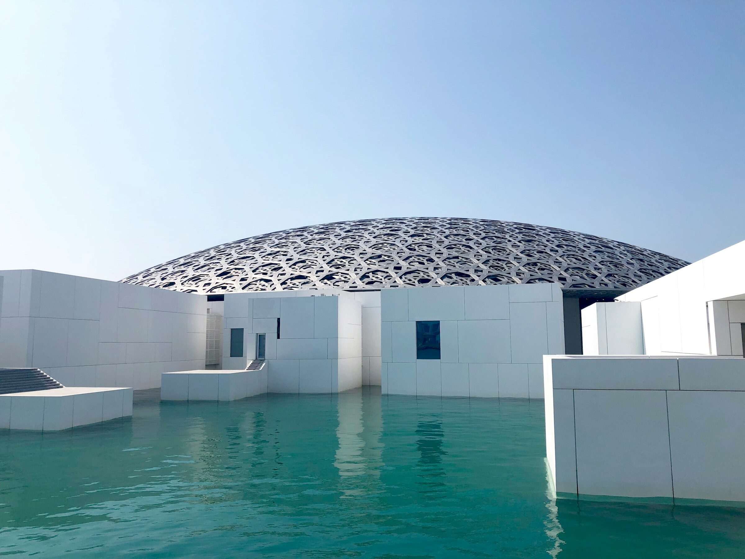 The white Louvre Abu Dhabi beside the water