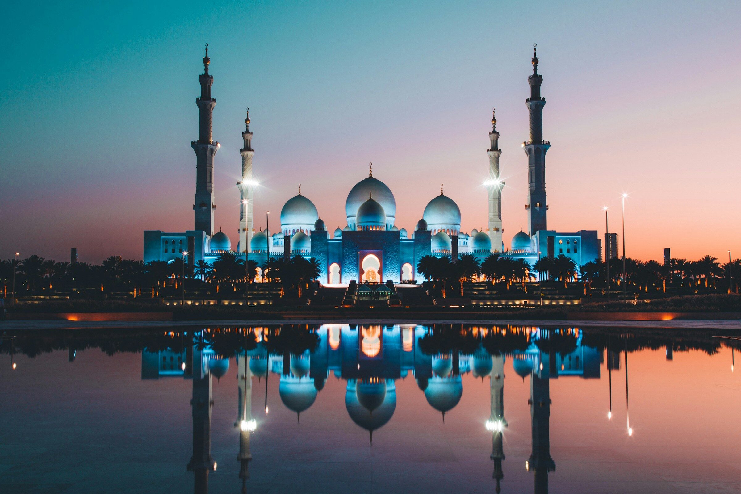 Sheikh Zayed Grand Mosque reflected in its pool at sunset