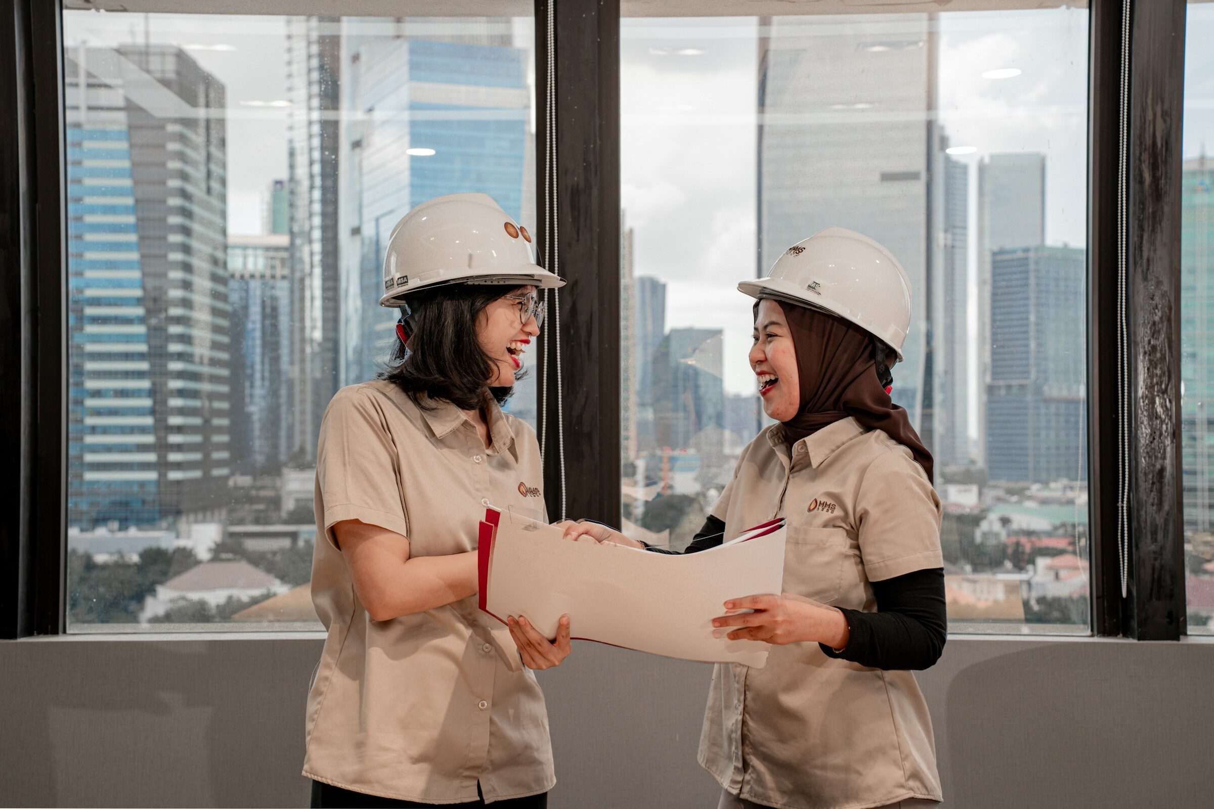 Engineers in hard hats reviewing facility plans and job specs