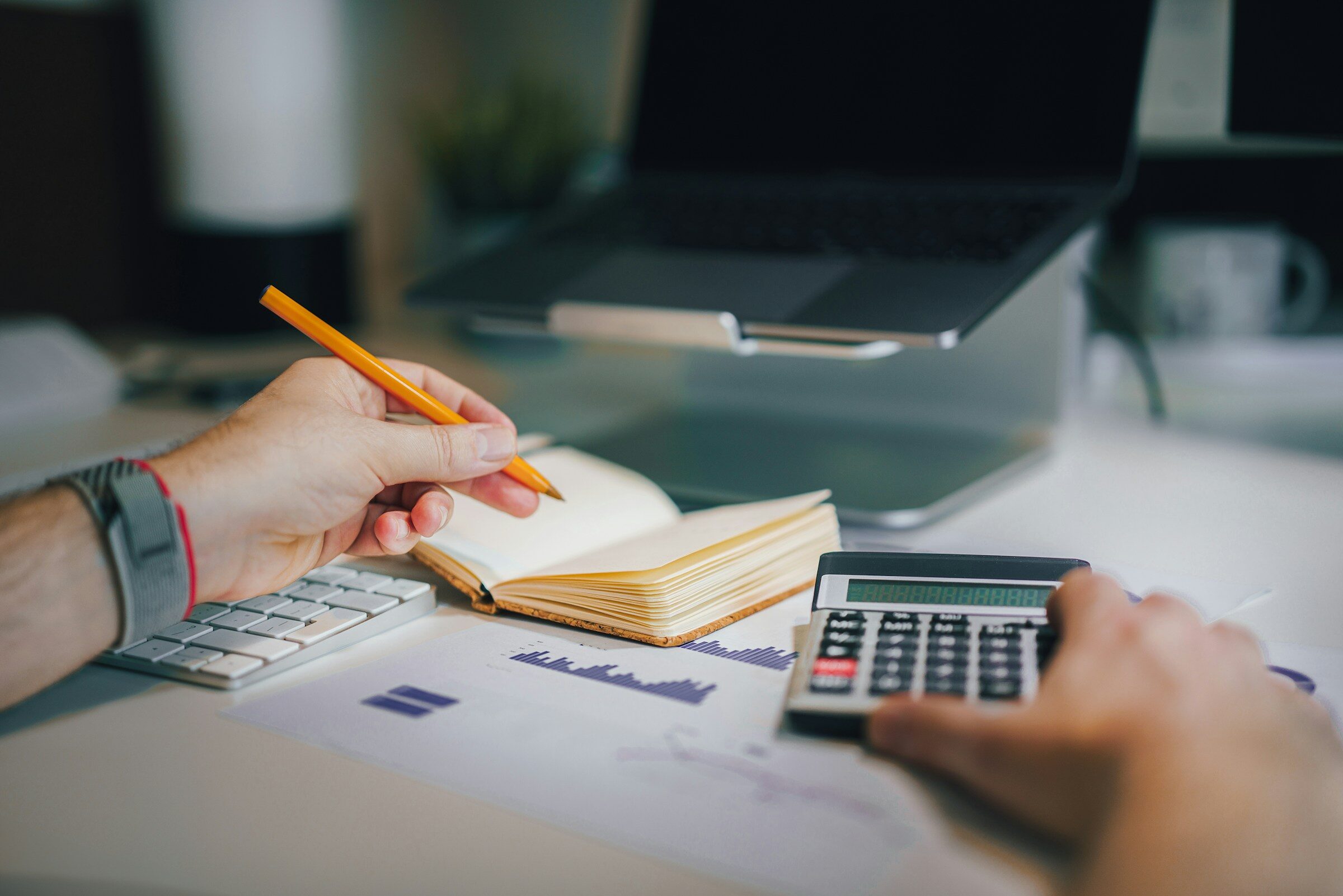 A calculator and notebook on a working desk