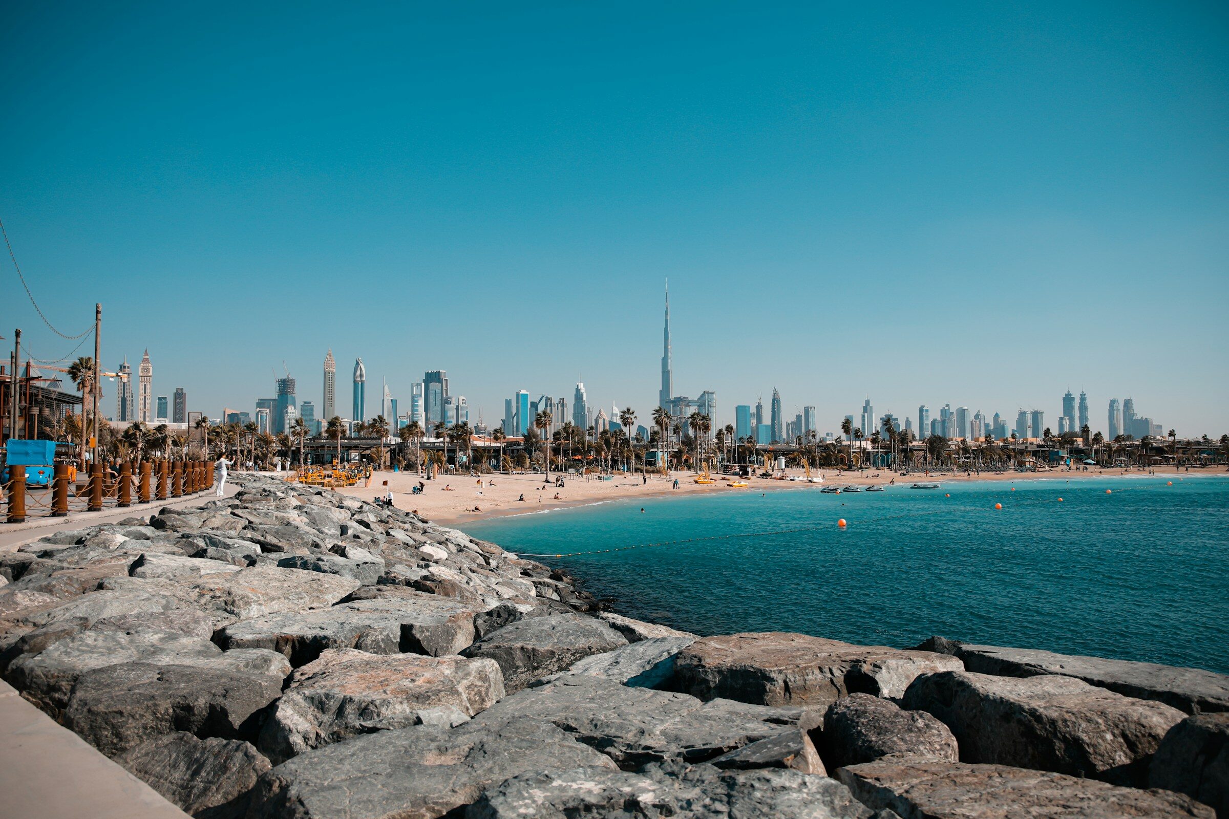 People on Jumeirah beach with the Dubai skyline behind