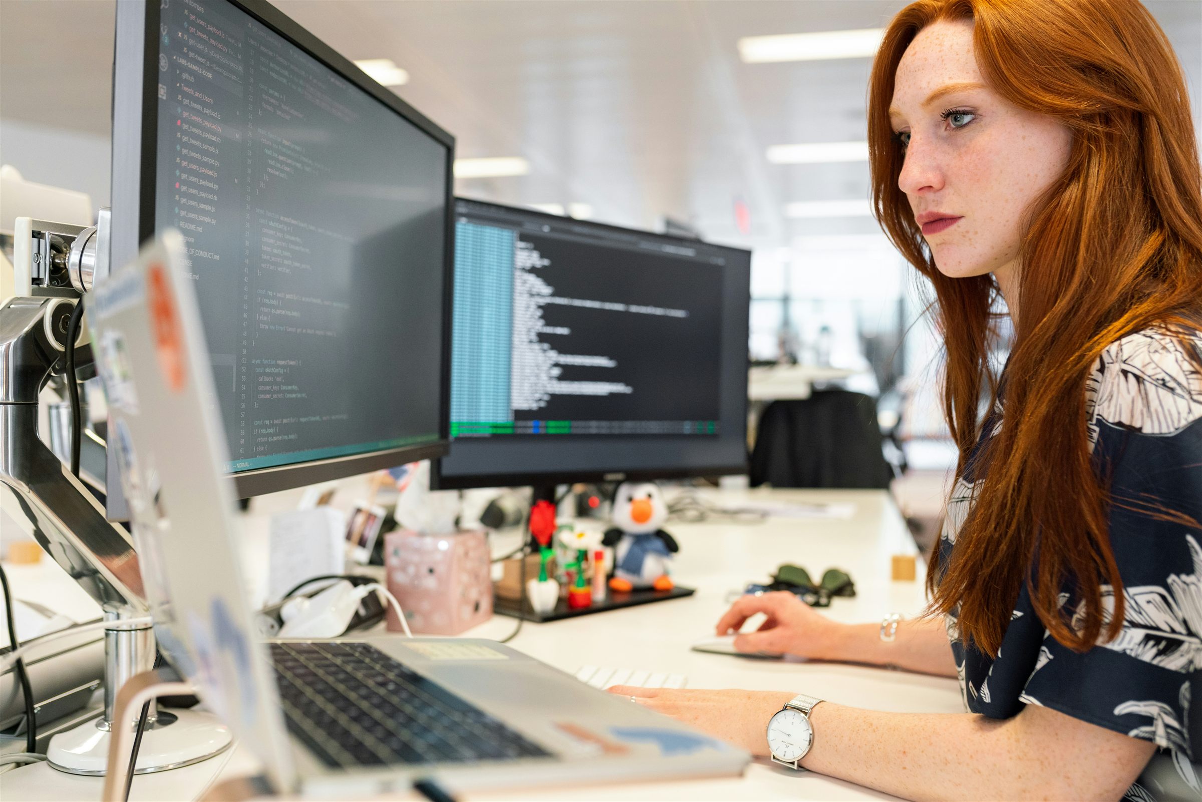 Developer writing website code across two monitors