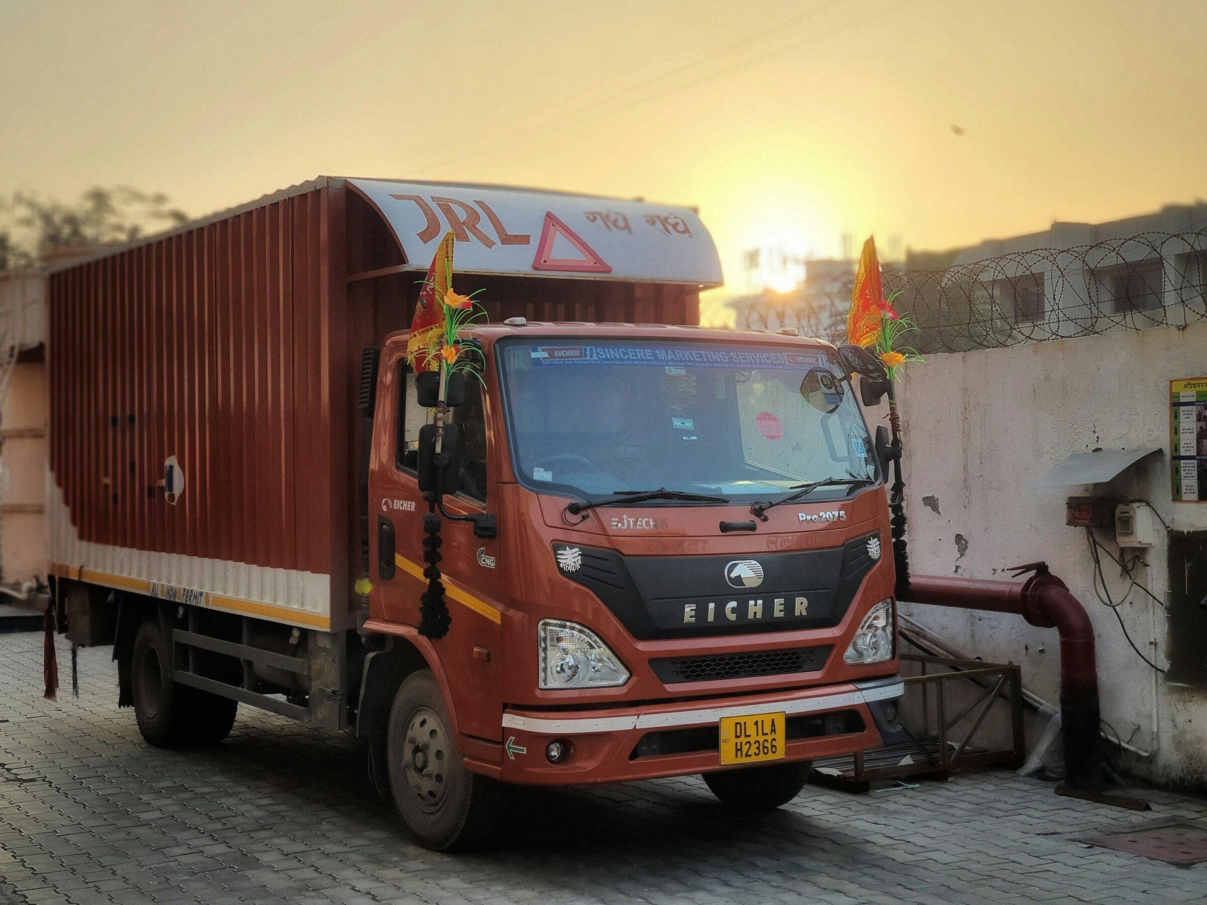 A red goods truck against a white wall