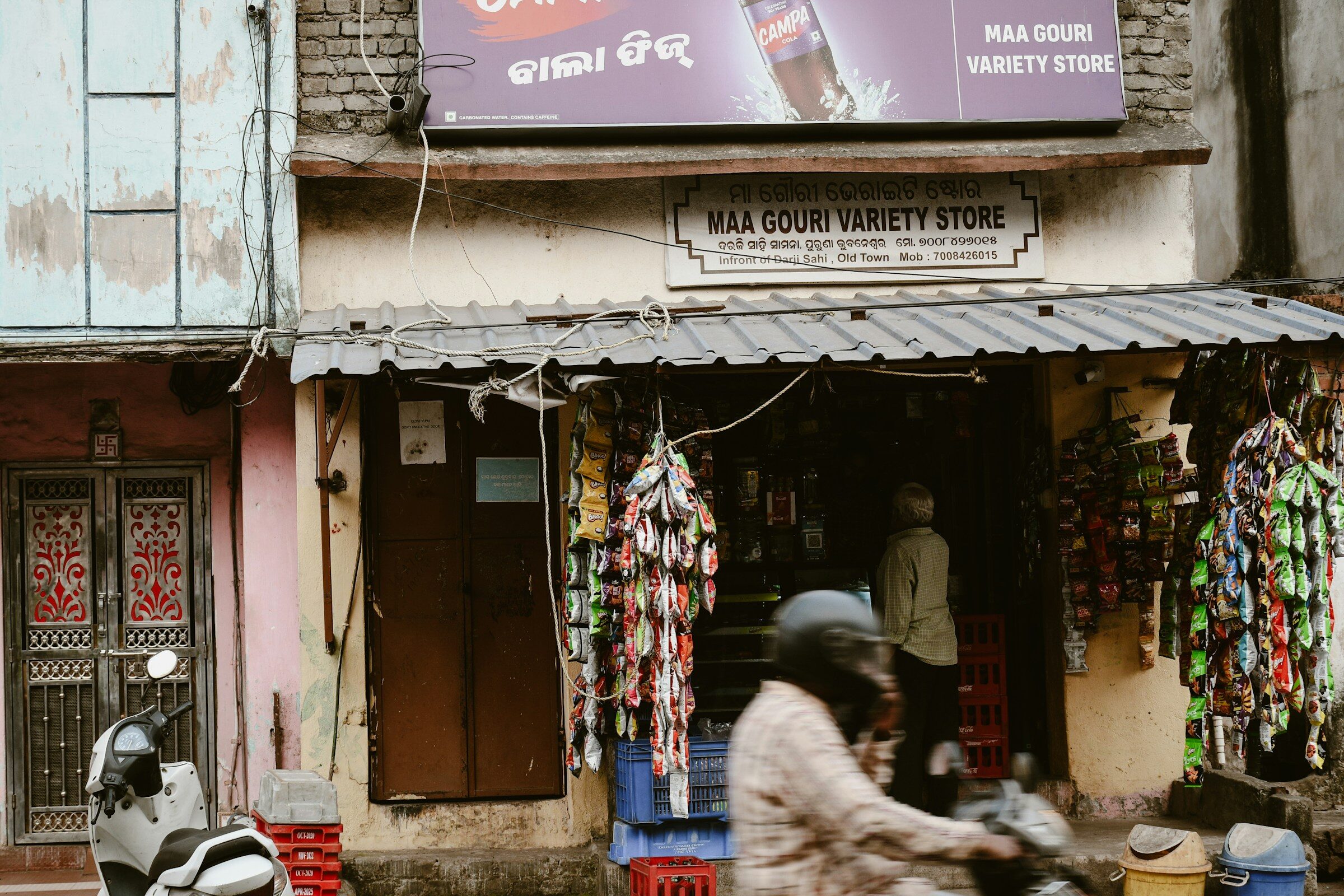 A variety store with a scooter passing in front