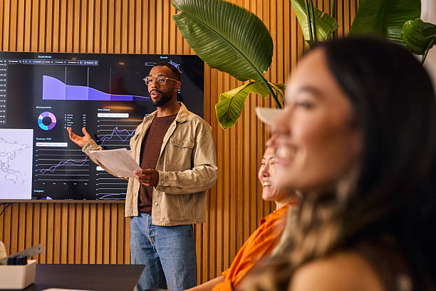 Manager presenting an ERP dashboard to colleagues in a meeting room
