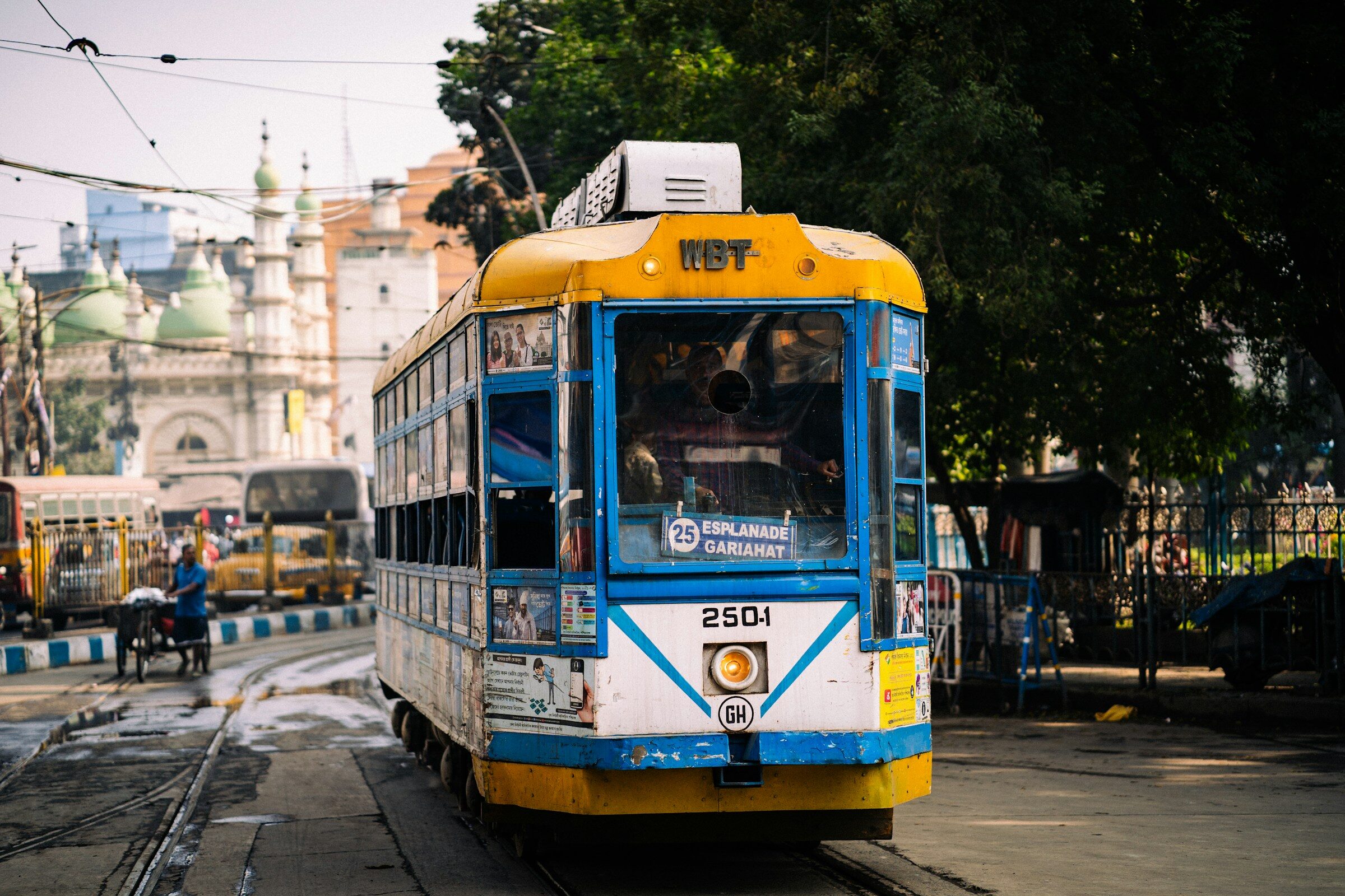 A yellow and blue tram on a Kolkata street