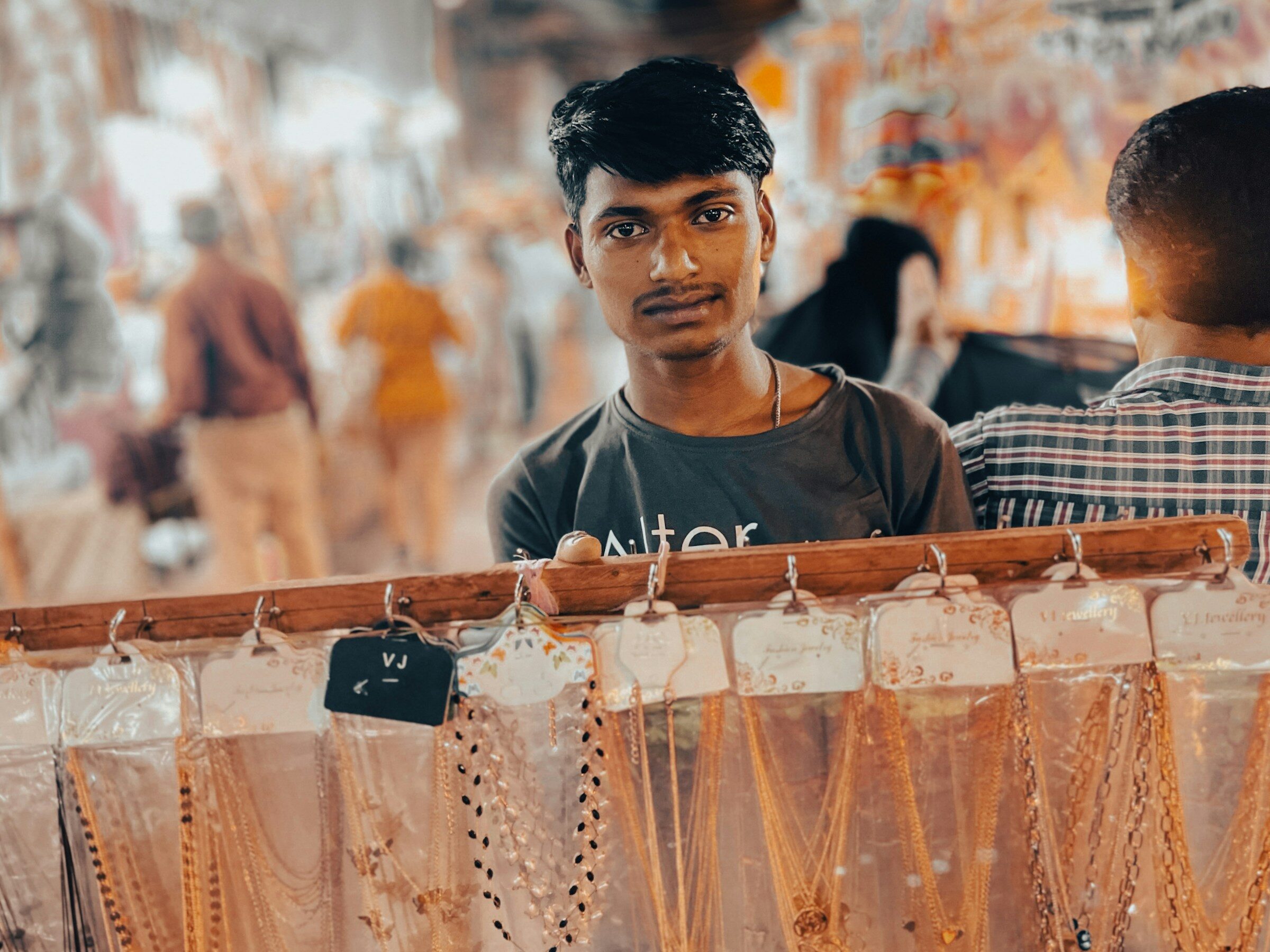 A shopkeeper behind a display of necklaces in a Mumbai jewellery shop