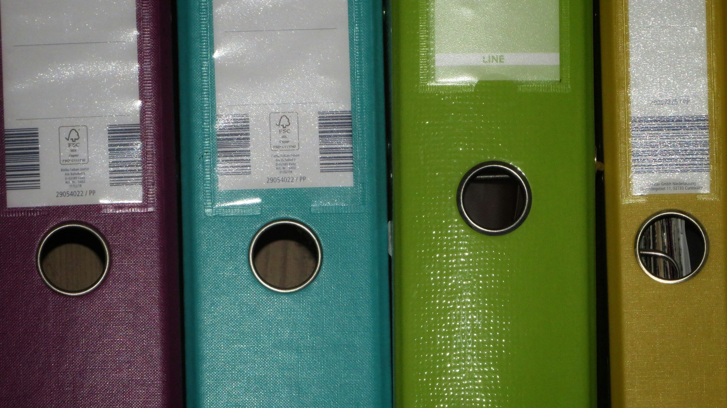 Rows of coloured binders on a shelf