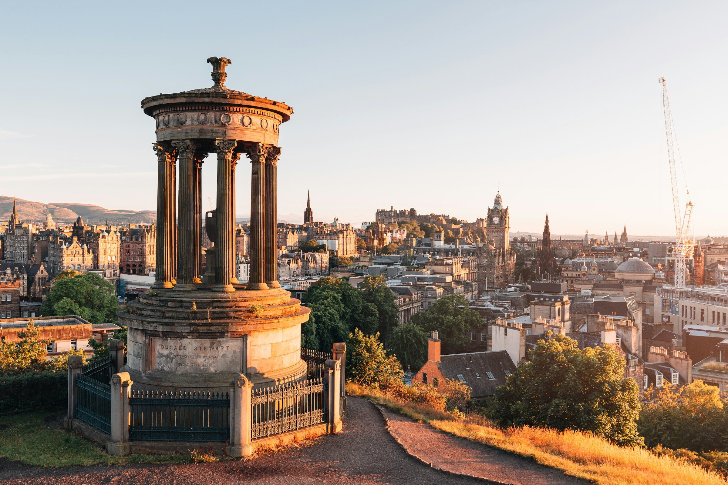 The Dugald Stewart Monument overlooking the Edinburgh skyline at golden hour