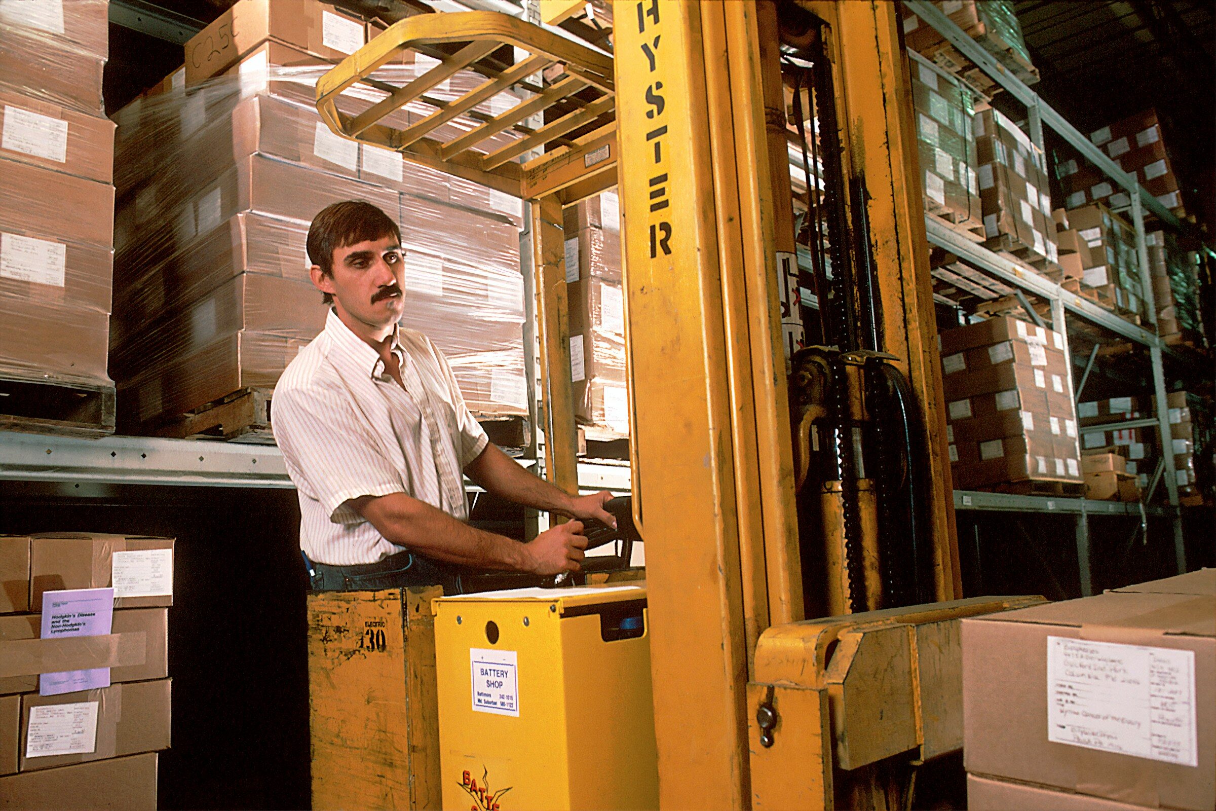 Forklift driver moving a load in a warehouse